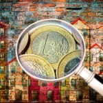 Public housing concept image painted on a old brick wall - Concept image seen through a magnifying glass with euro coins - I'm the copyright owner of the graffiti images used in this picture